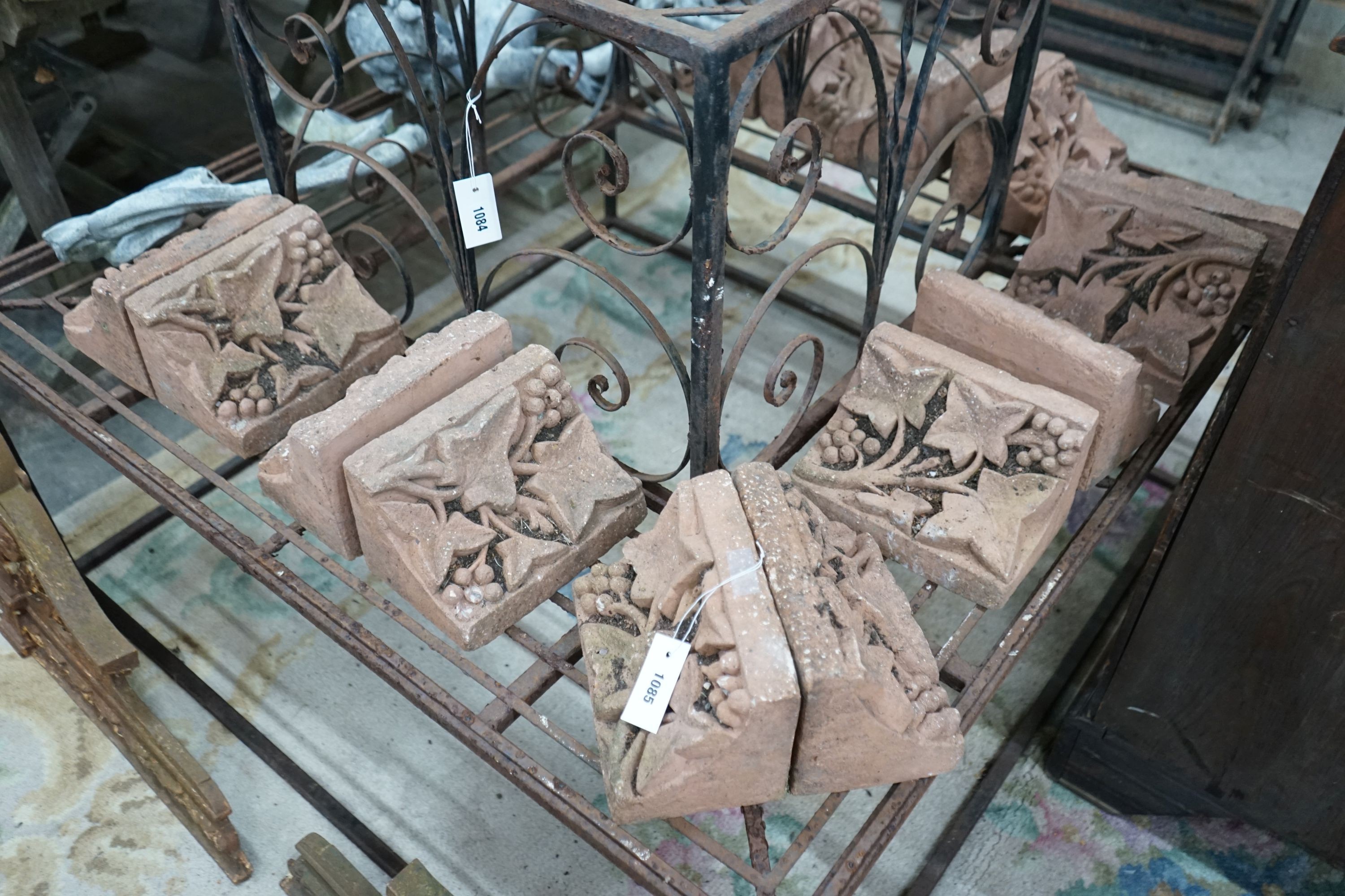 Fourteen terracotta edging tiles moulded with fruiting vines, each width 23cm, depth 14cm, height 15cm